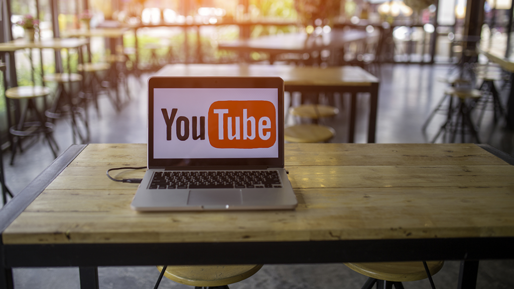 YouTube image on a laptop resting on a restaurant table.