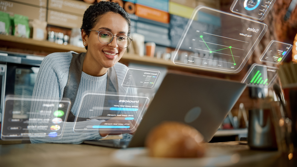 Restaurant worker looking at a laptop while futuristic UI overlays appear around her.