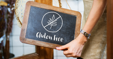 Restaurant worker putting up a sign that says 'Gluten Free'
