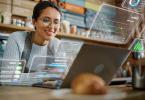 Restaurant worker looking at a laptop while futuristic UI overlays appear around her.